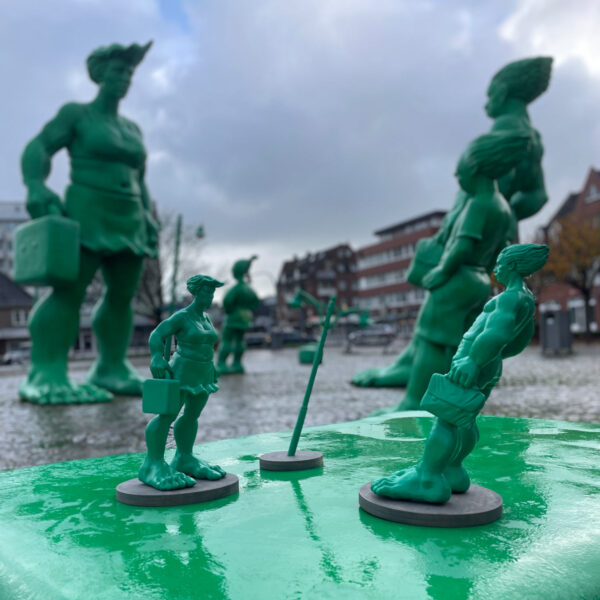 Sylter Riesen, limitierte Auflage, 30 cm Größe, 100 Exemplare, stehen im Set auf dem originalen grünen Koffer auf dem Bahnhofsvorplatz Westerland auf Sylt.